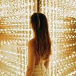 a woman standing in front of a wall of lights